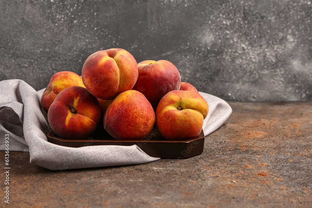 Tray with sweet peaches on dark background