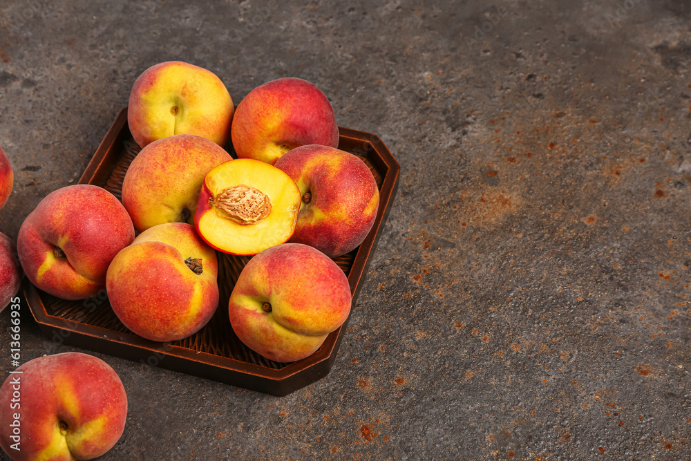 Tray with sweet peaches on dark background