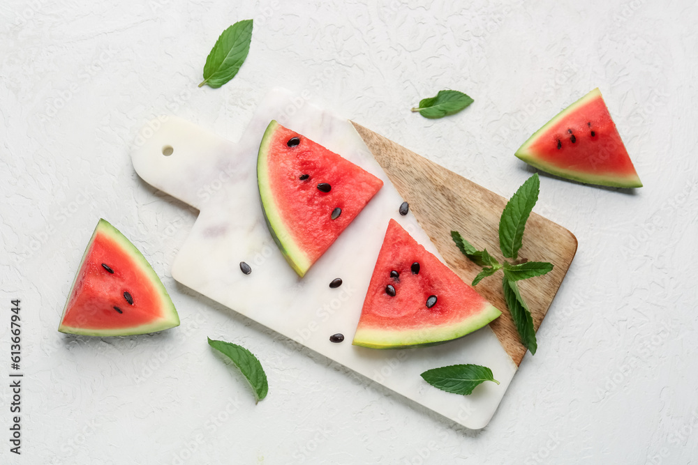 Board with pieces of fresh watermelon and mint on white background