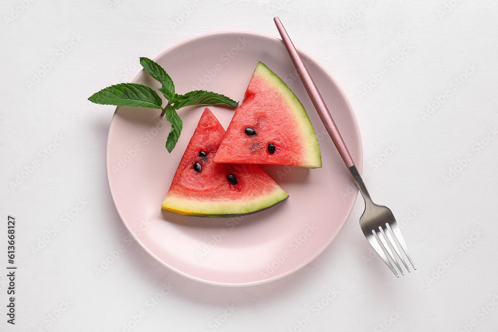 Plate with pieces of fresh watermelon and mint on white background