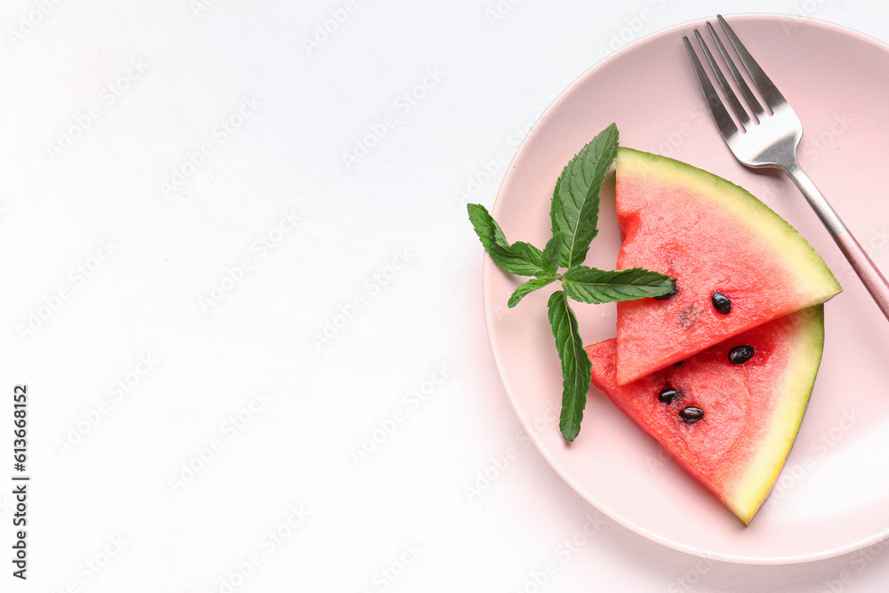 Plate with pieces of fresh watermelon and mint on white background