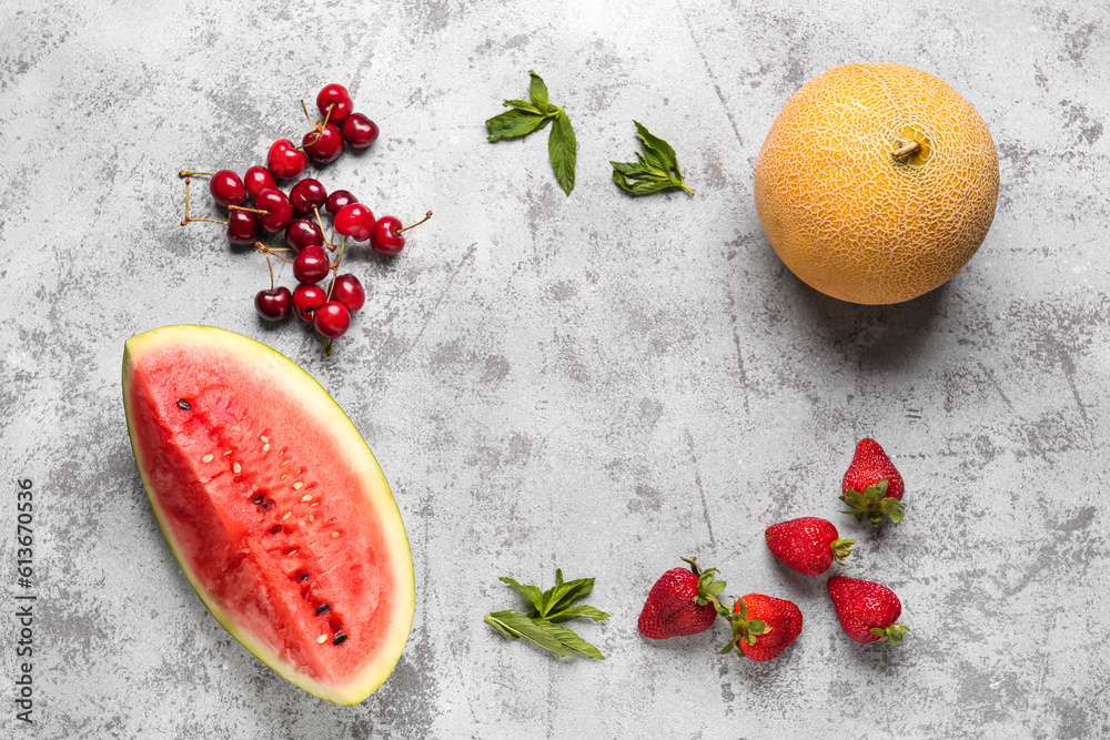 Frame made of fresh watermelon and different berries on grey background