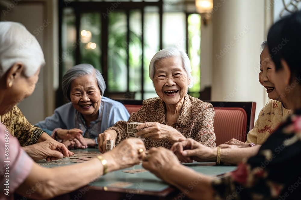 Joyful group of Asian seniors playing cards and sharing laughter in a retirement nursing home. Gener