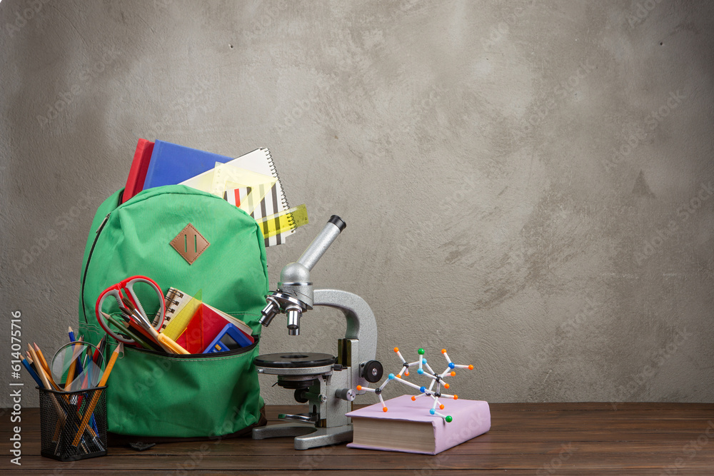 Back to school - books and school backpack on the desk in the auditorium, Education concept.