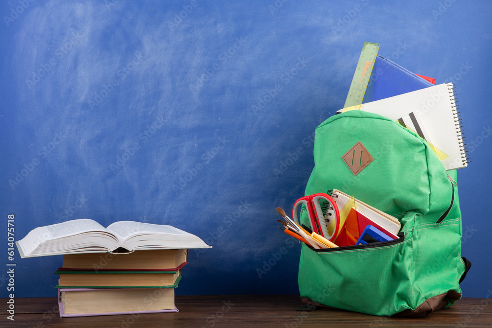 Back to school - books and school backpack on the desk in the auditorium, Education concept.