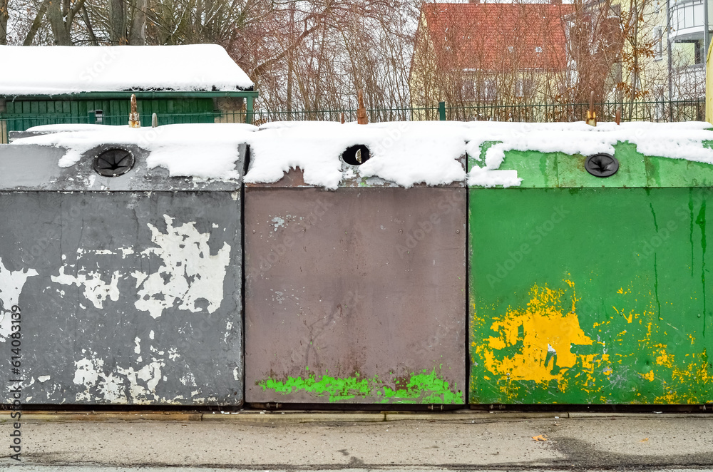 View of garbage containers in city on winter day