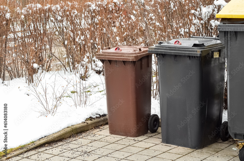 View of garbage containers in city on winter day