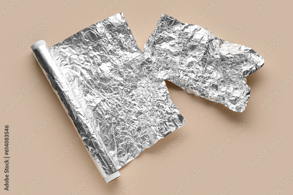 Crumpled aluminium foil on color background