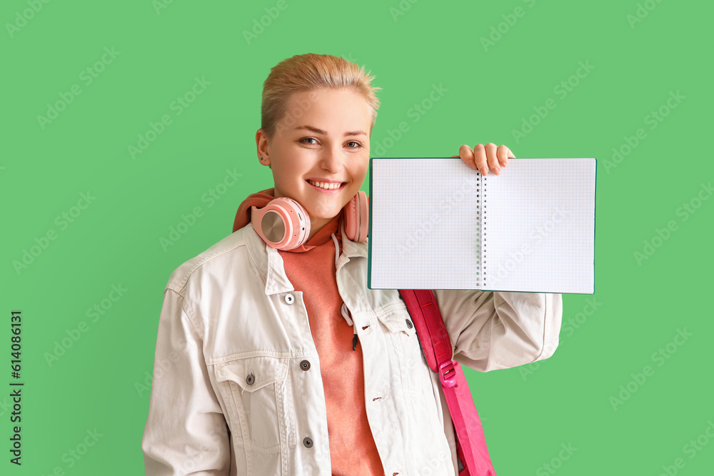 Female student with notebook on green background