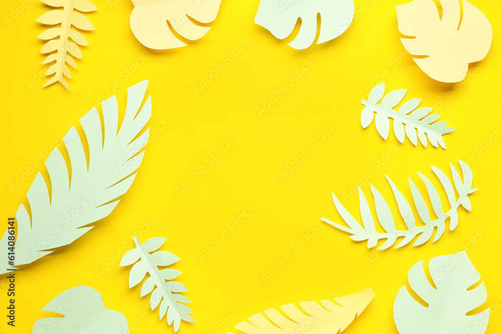 Frame made of paper tropical leaves on yellow background