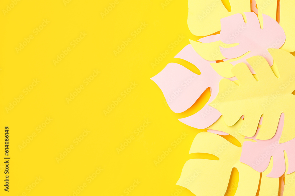 Paper tropical leaves on yellow background