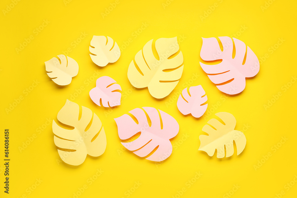 Paper tropical leaves on yellow background