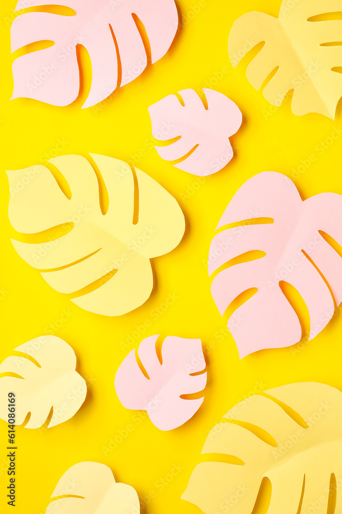 Paper tropical leaves on yellow background