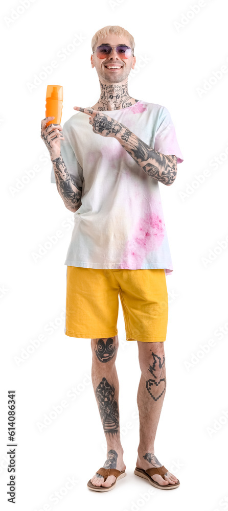 Tattooed man with sunscreen cream on white background