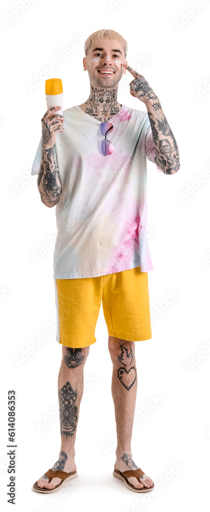 Tattooed man with sunscreen cream on white background