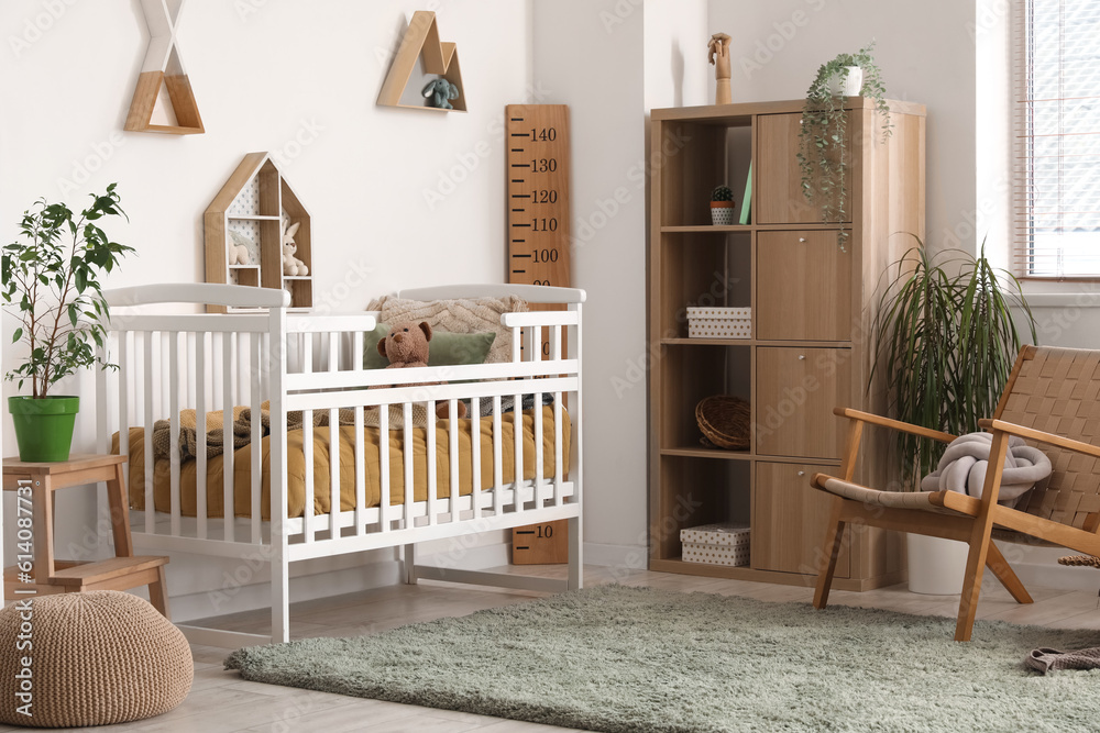 Interior of childrens bedroom with crib, shelves and toys