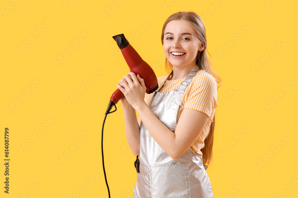 Female hairdresser with dryer on yellow background