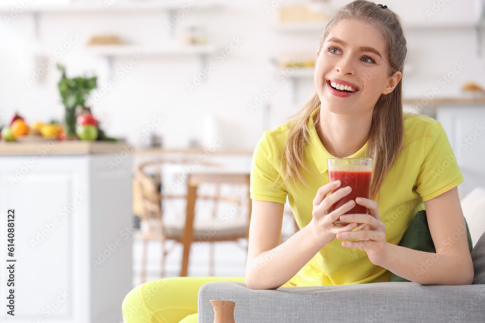 Sporty young woman with glass of vegetable juice in kitchen