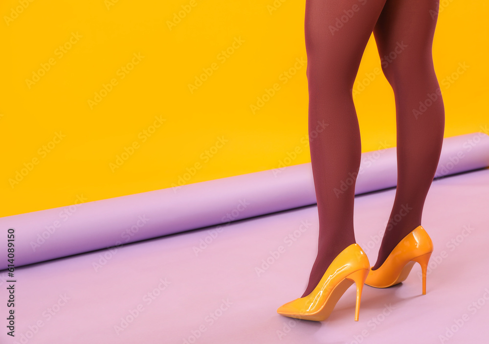 Female legs in black tights and yellow high heels on color background