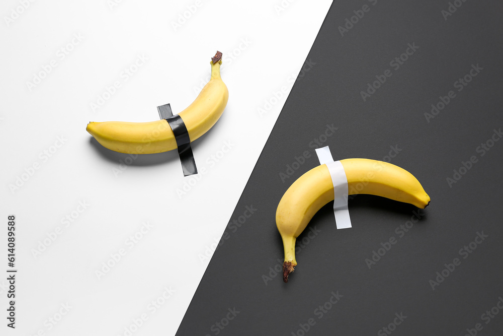 Bananas with adhesive tapes on black and white background