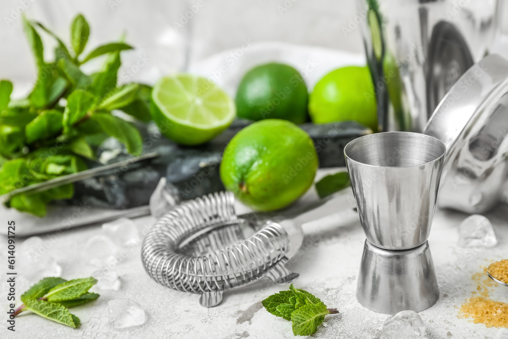 Measure cup and ingredients for preparing mojito on light background