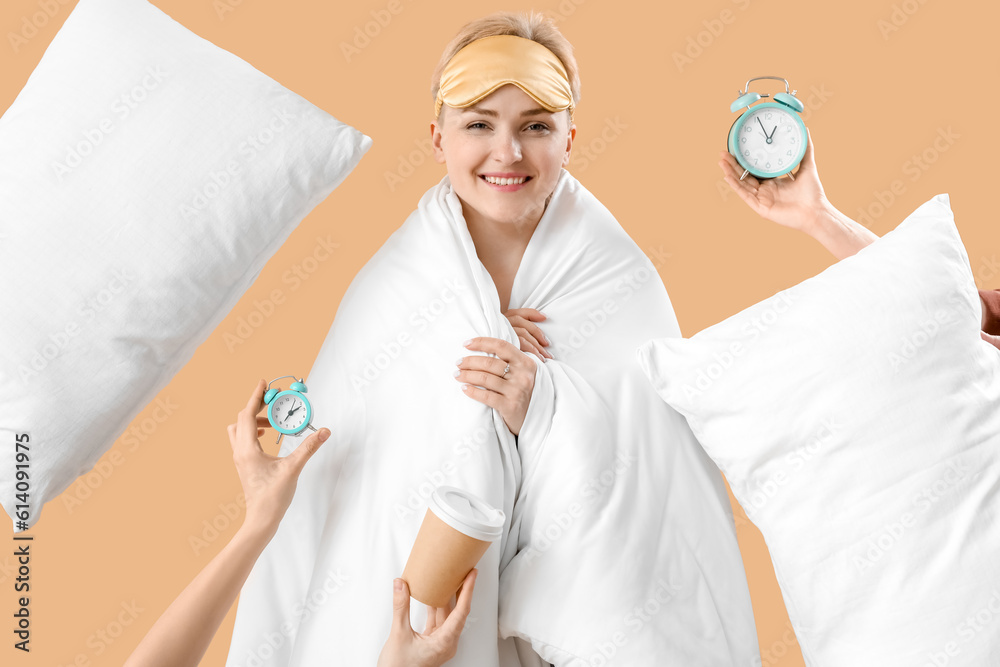 Young woman in blanket and female hands with alarm clocks on beige background