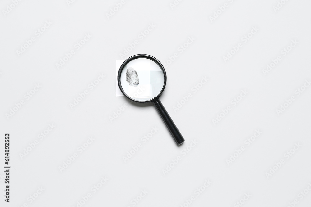 Magnifier and paper with fingerprint on grey background. Detective concept