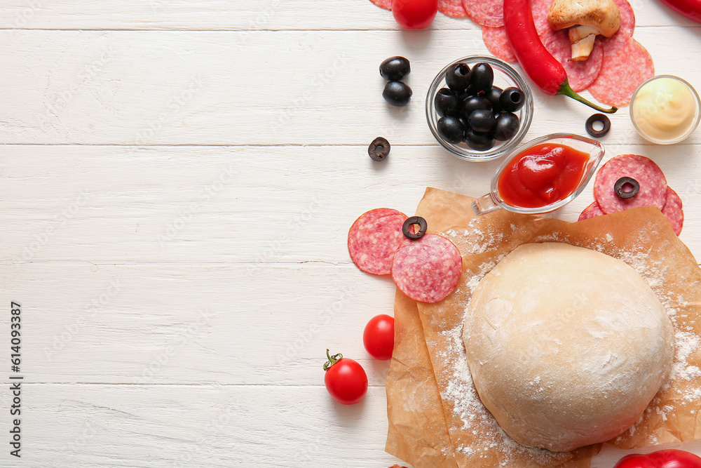 Different ingredients for preparing pizza on white wooden background