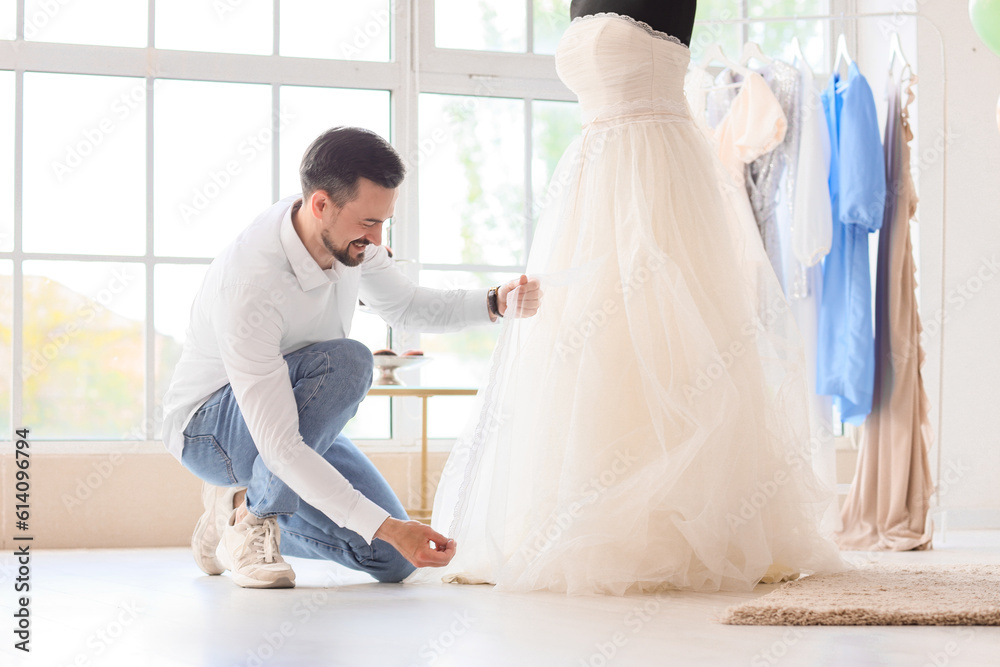 Male wedding planner with dress working in office