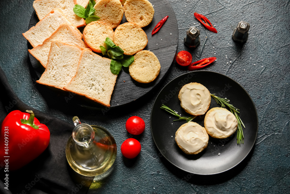 Plate of tasty croutons with cream cheese on dark background