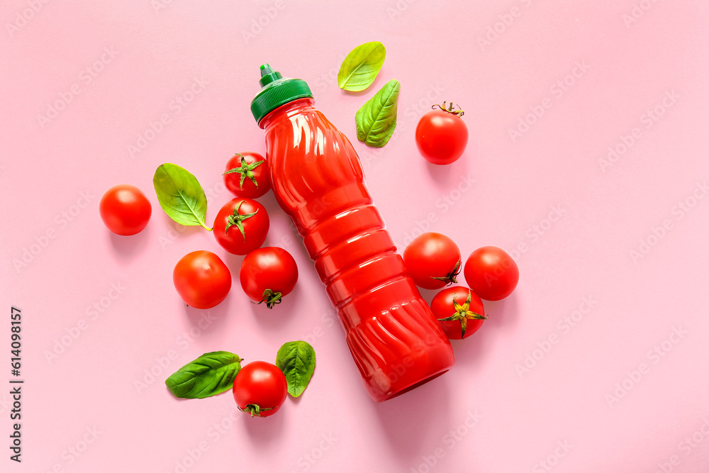 Bottle of ketchup and tomatoes on pink background