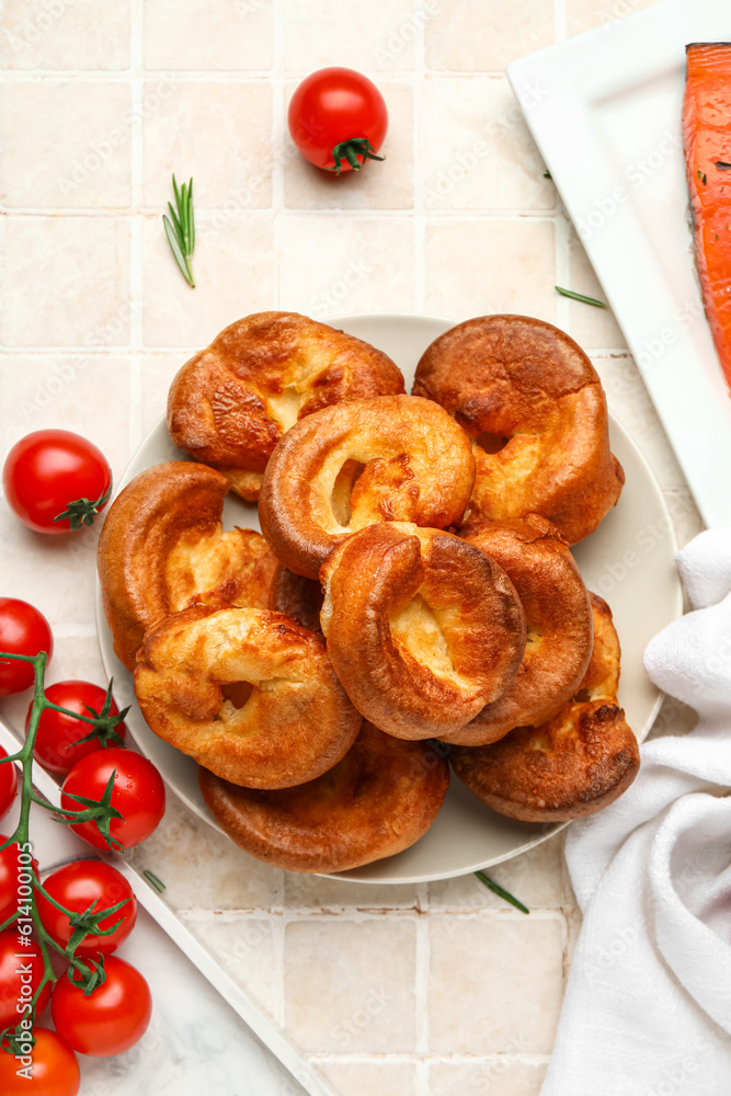 Plate with tasty Yorkshire pudding on light tile background