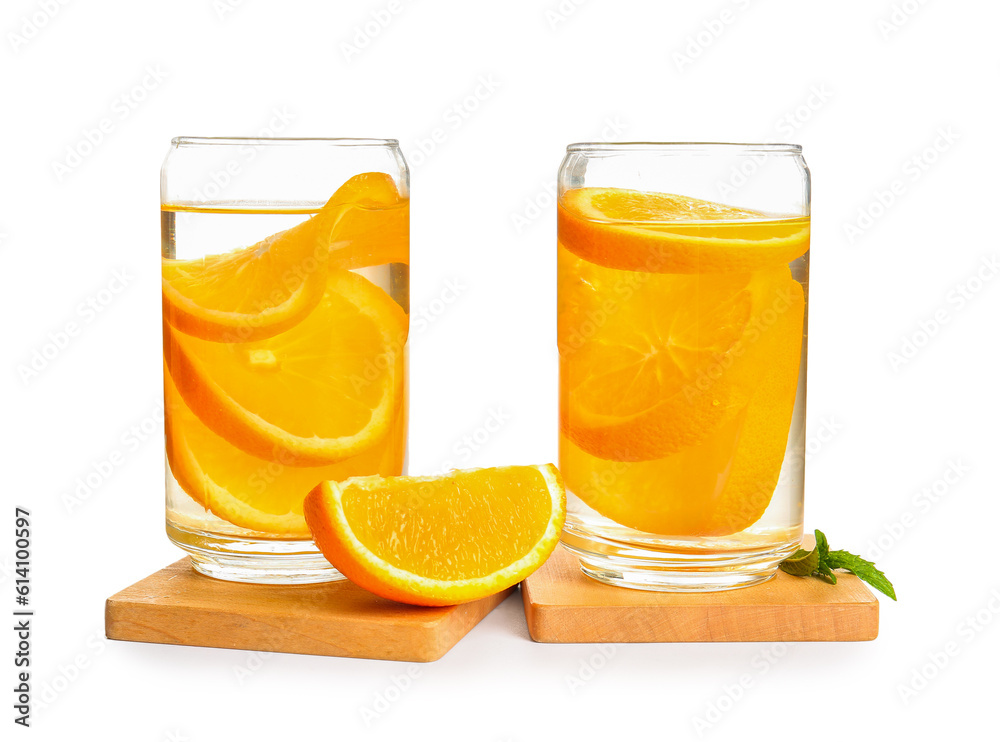 Glasses of infused water with orange slices on white background