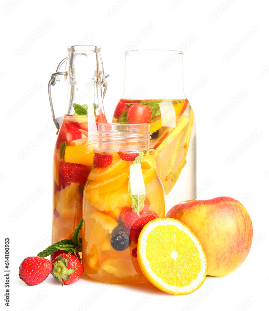 Bottles of infused water with different sliced fruits on white background