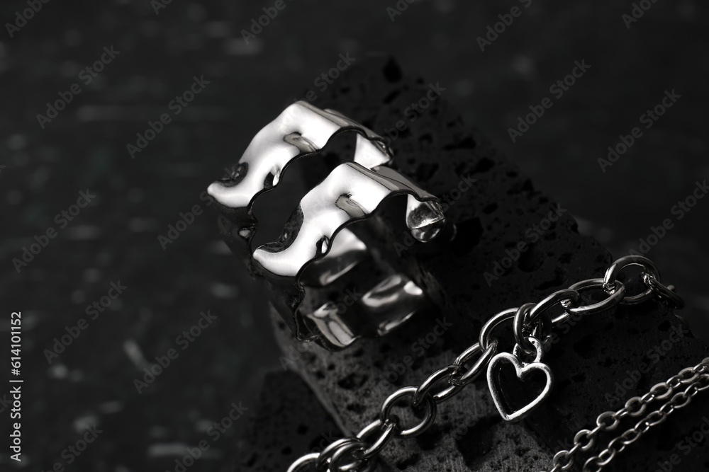 Decorative podium with beautiful jewellery on black background