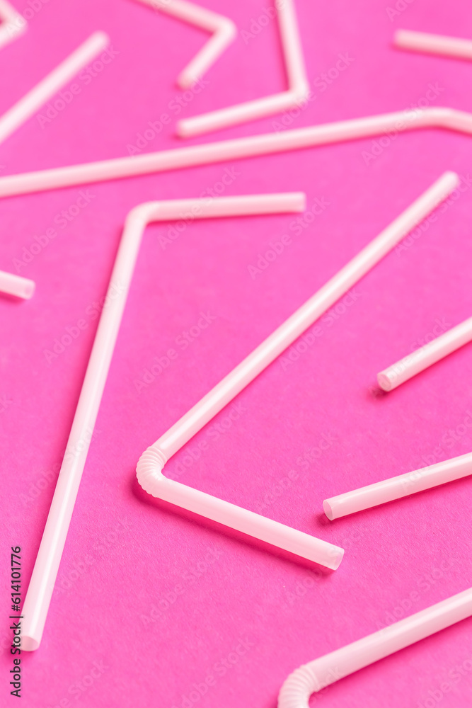 White plastic straws on pink background