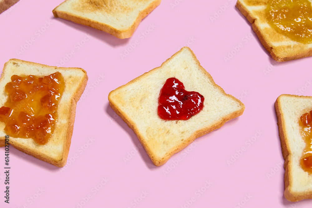 Toasts with different jams on pink background, closeup