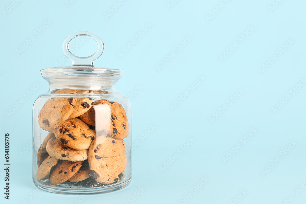 Jar with cookies on blue background