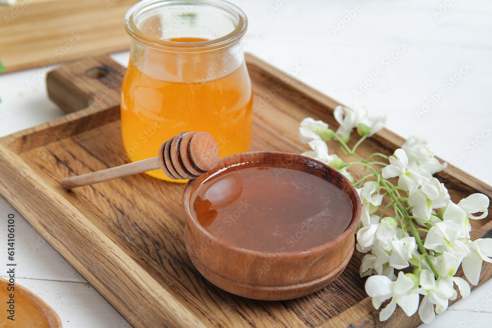 Composition with sweet honey and acacia flowers on light wooden table, closeup