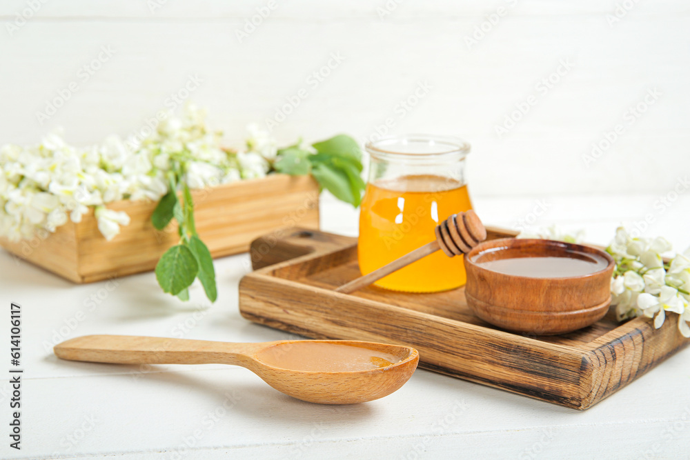 Composition with sweet honey and acacia flowers on light wooden table