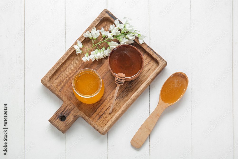 Composition with sweet honey and acacia flowers on light wooden background