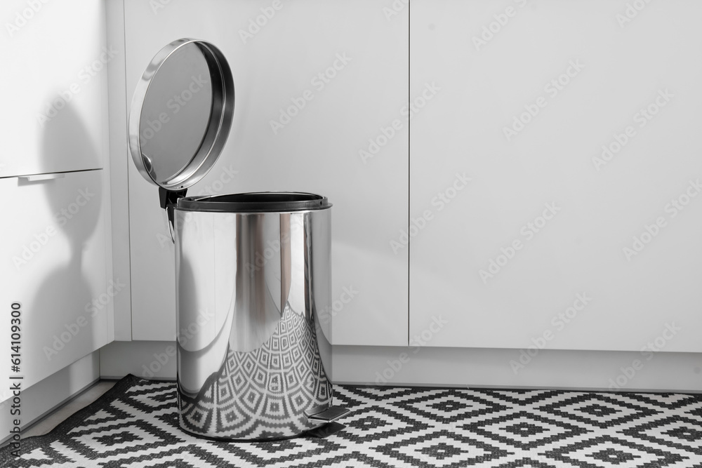 Opened metallic trash bin in interior of modern kitchen