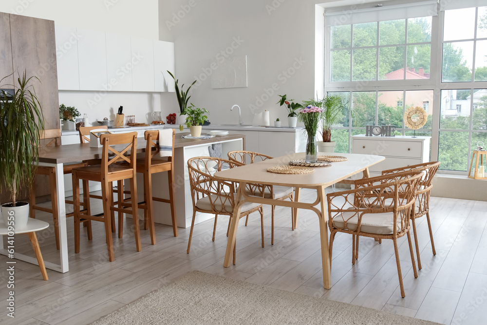 Interior of light open plan kitchen with dining table and island