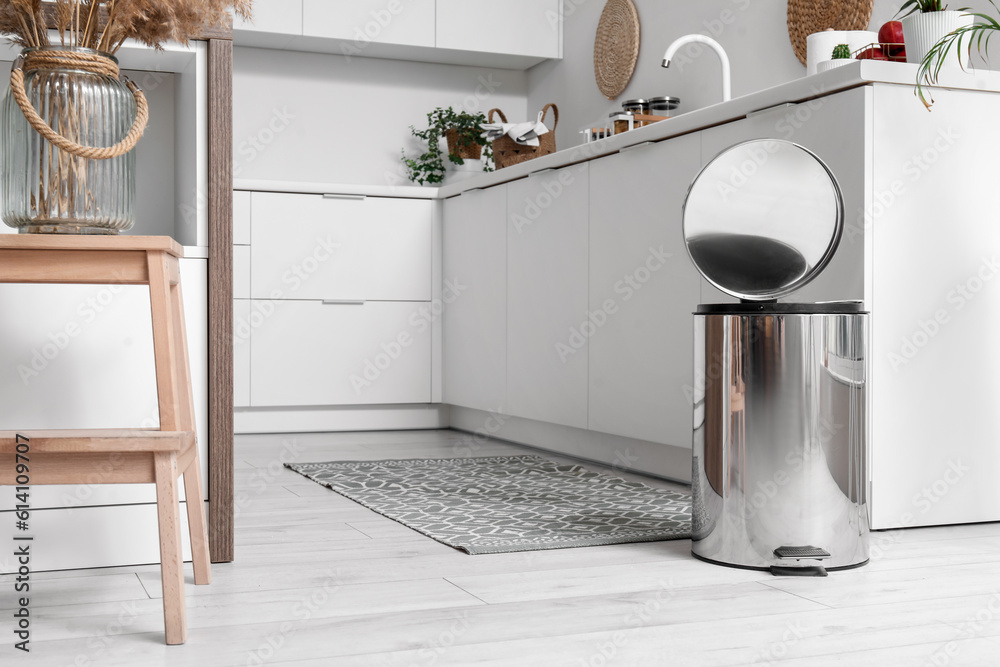 Opened metallic trash bin in interior of modern kitchen