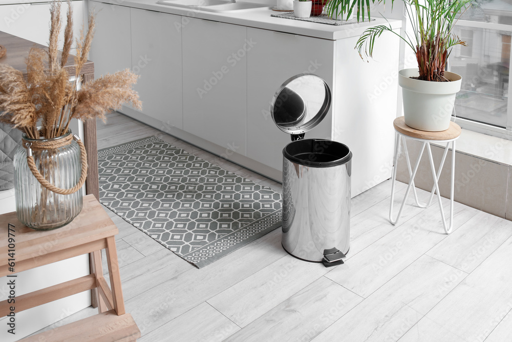 Opened metallic trash bin in interior of modern kitchen