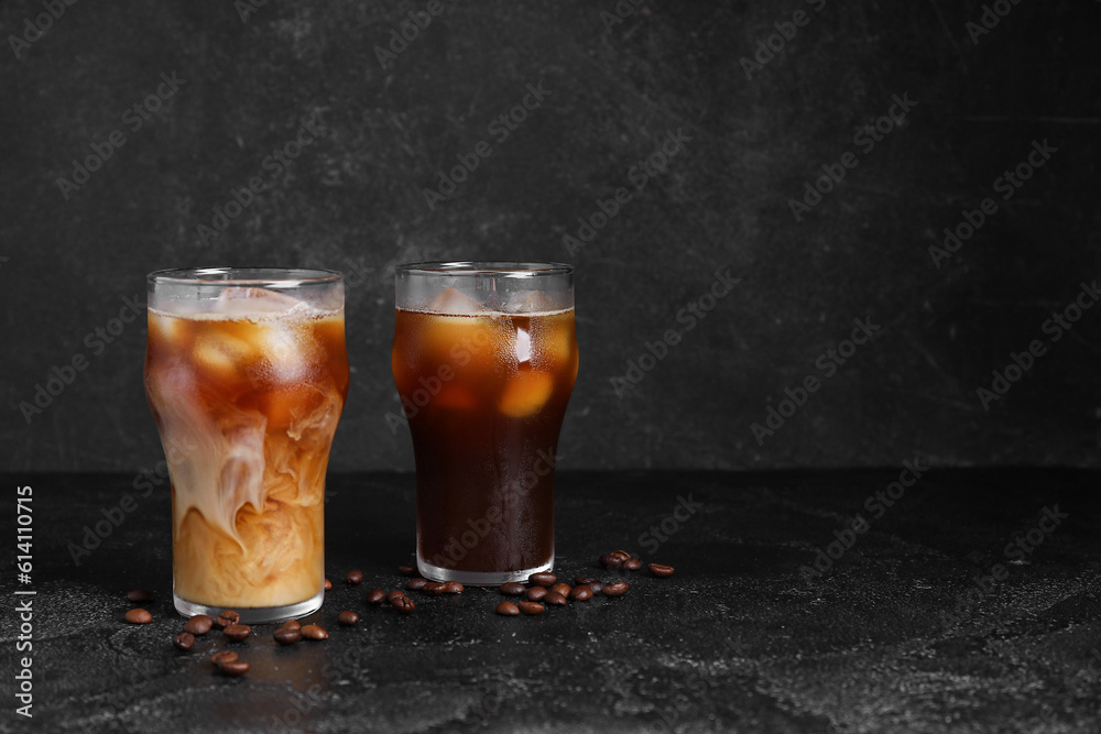 Glasses of tasty ice coffee with milk on black background