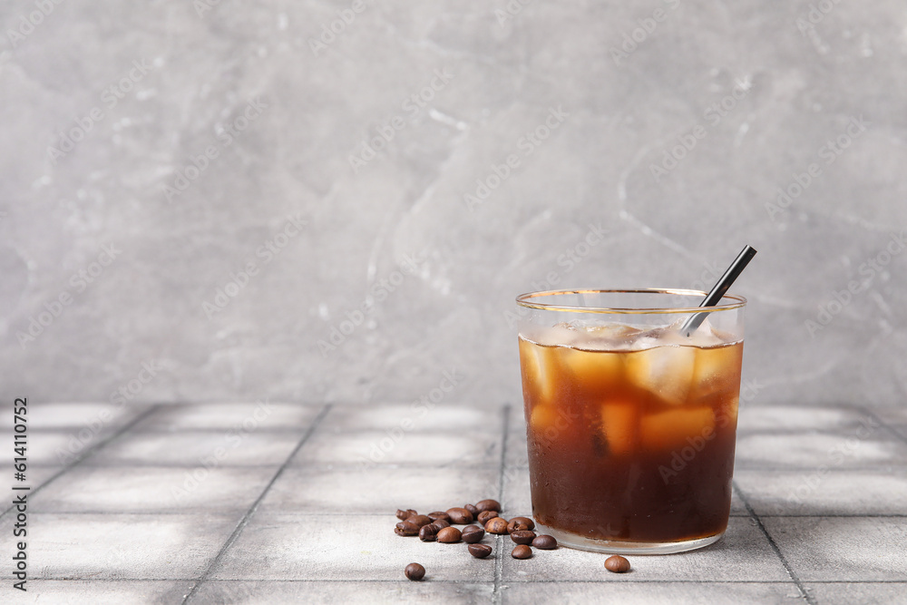 Glass of tasty ice coffee with milk on table