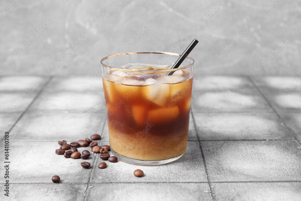 Glass of tasty ice coffee with milk on table