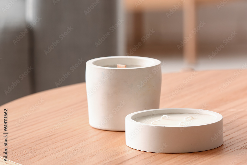 Holders with candles on table in room, closeup