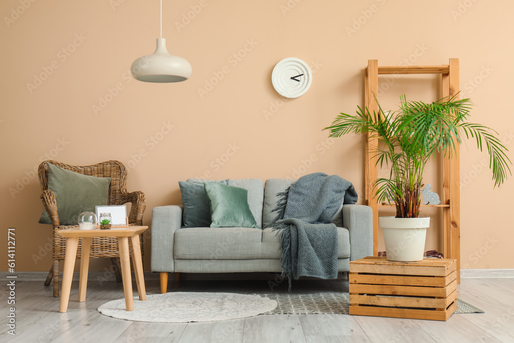 Interior of living room with cozy grey sofa, armchair and coffee table